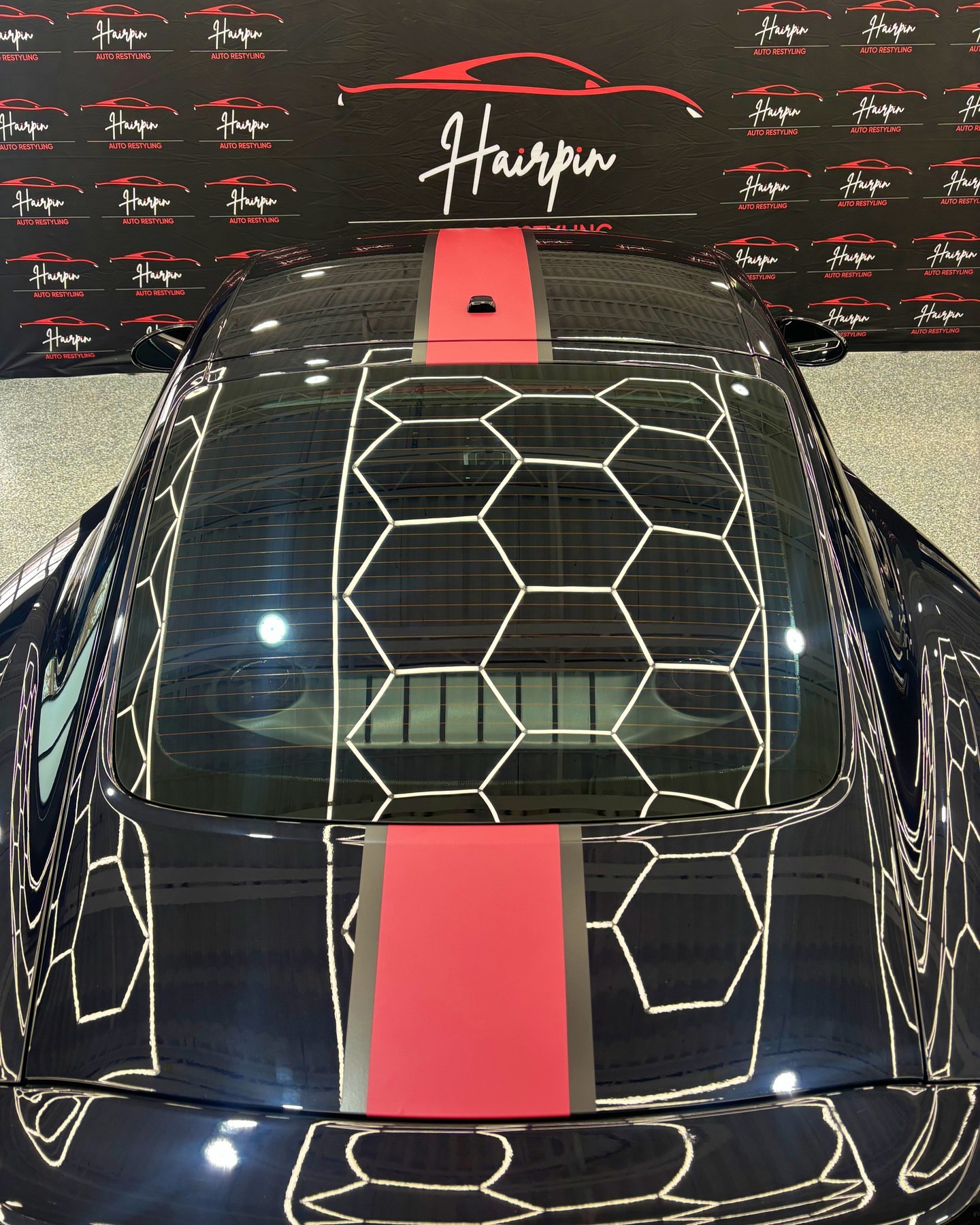 Red vinyl racing stripe installed on a black Porsche 718